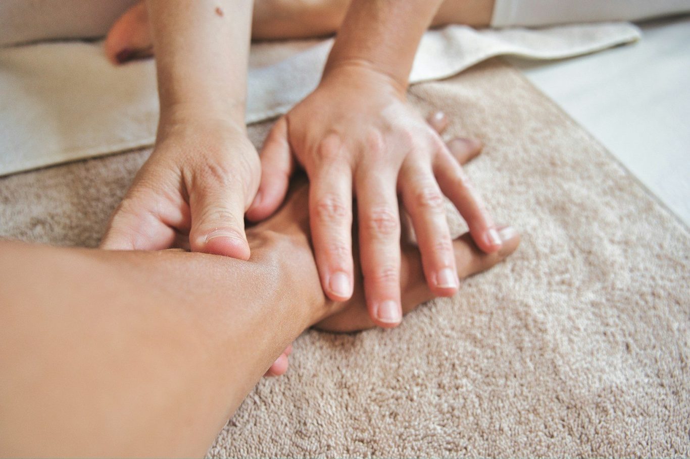 Manuelle Lymphdrainage in Wittenberg Hände führen eine Massage auf einer Hautfläche durch.