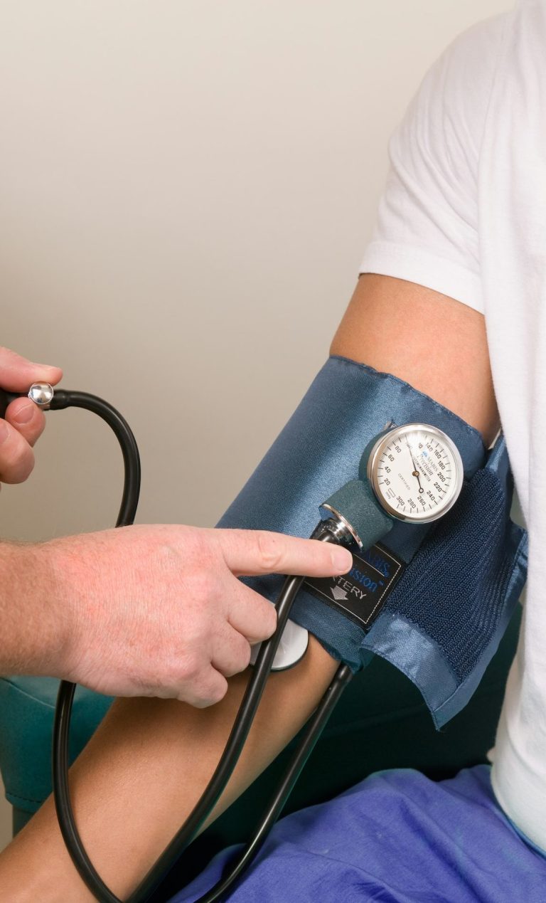 Blutdruckmessung an einem Oberarm mit sphygmomanometrischen Geräten.