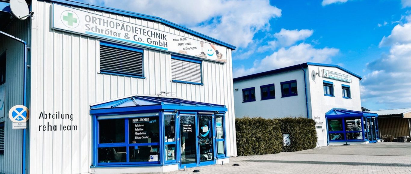 Fassadenansicht eines modernen Firmengebäudes mit blauer Tür und Werbung.