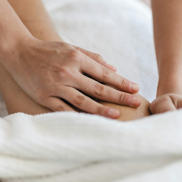 Eine Person erhält eine Massage am Oberkörper, Hände auf der Brust.